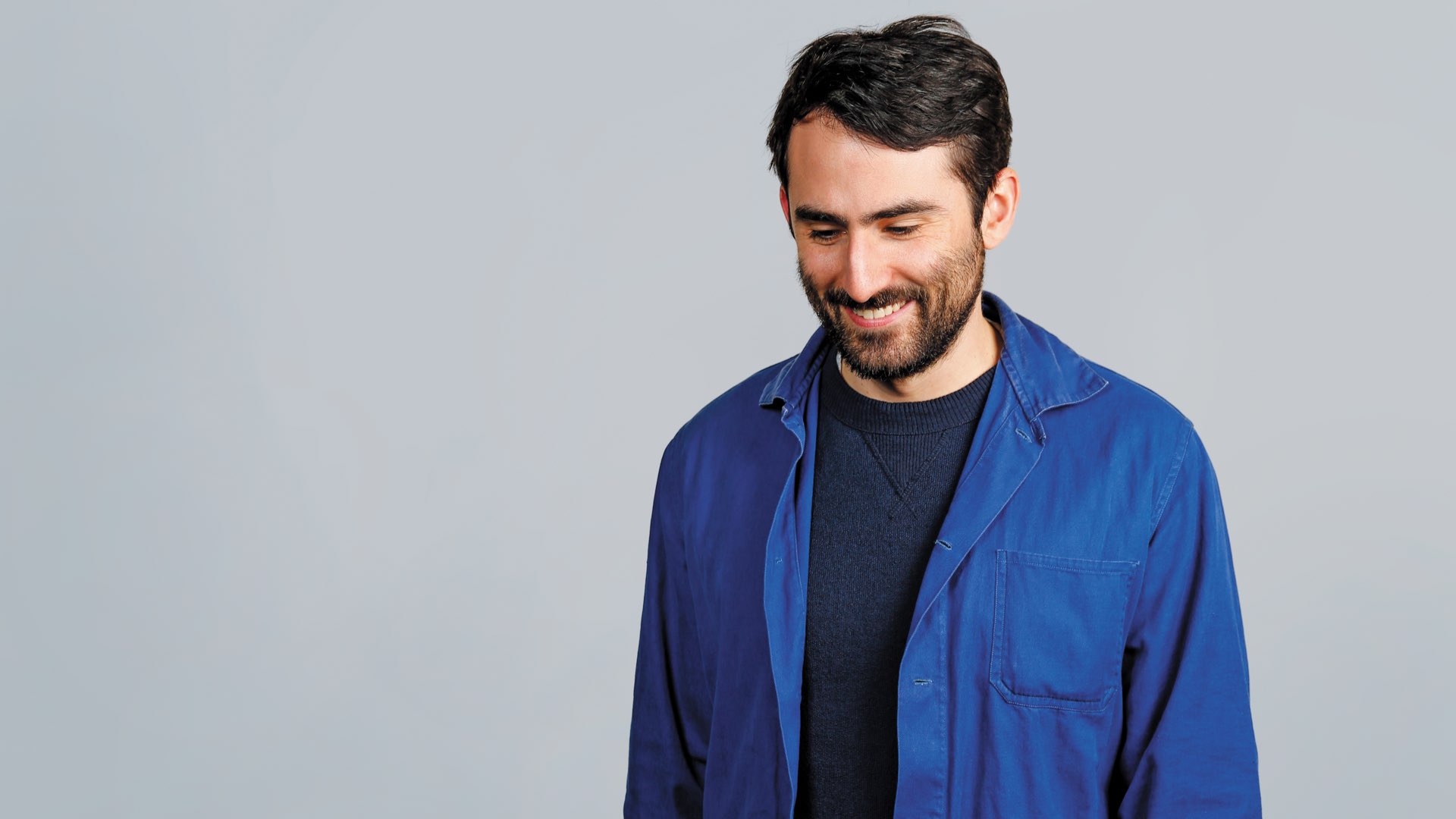 Villanova School of Business alumnus Ryan Burke with a beard in a blue denim button down and jeans