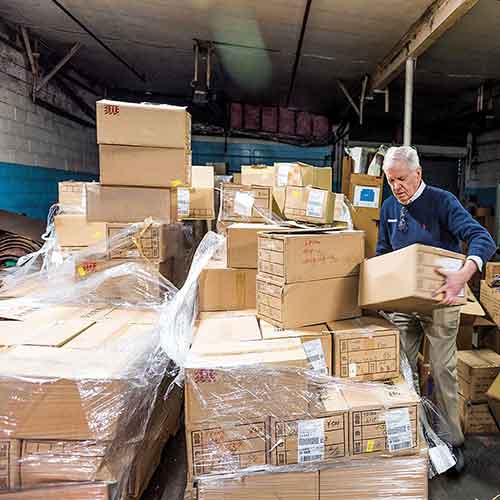 1983 Tom Costello Jr. in a room full of boxes of socks