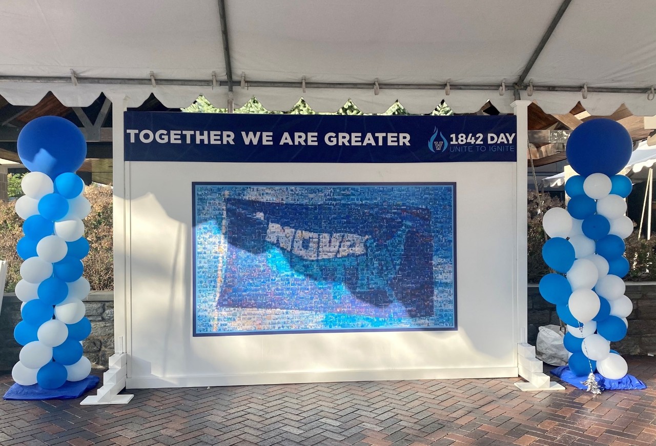 1842 Day Mosaic image of a Nova Nation glad with blue and white balloons on either side, and a banner with the words "Together we are Greater"