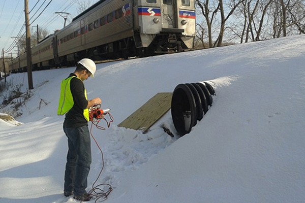 Michael Pluimer Michael Pluimer, graduate of Villanova's doctoral program in engineering, works on a project by train tracks.