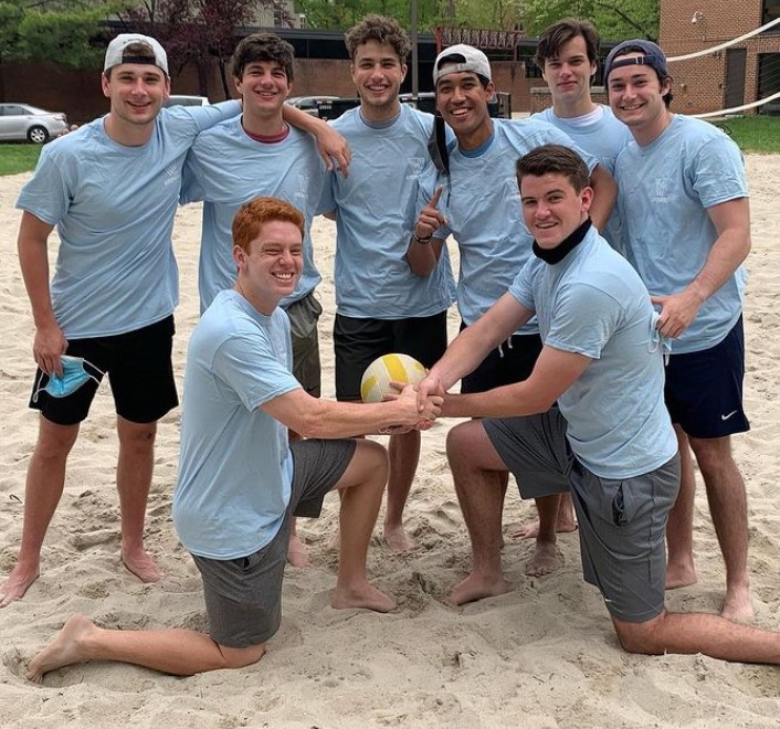 Male students posing for sand volleyball champion photo