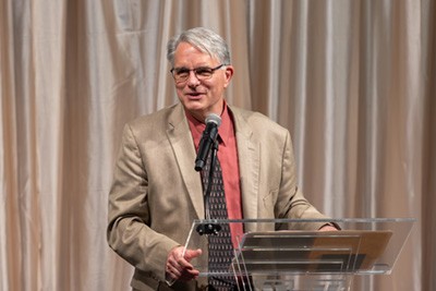 Mark Doorley, PhD, presenting at a podium.