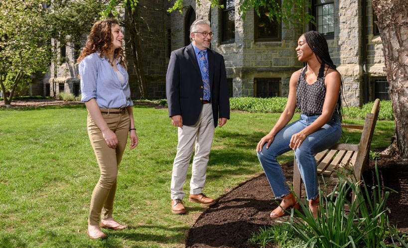 Africana Studies Students and a faculty member talking outside of a building.
