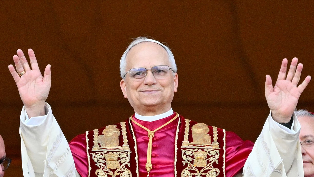 Pope Leo XIV raises his hands.