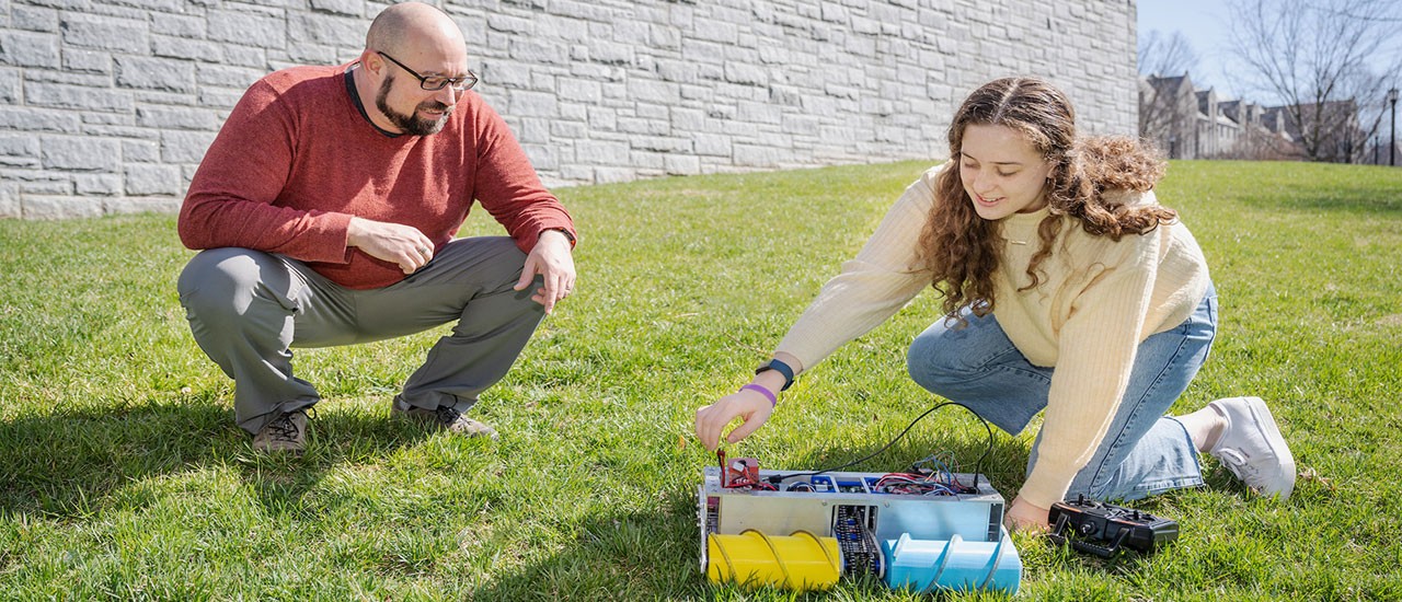 Engineering professor and student outside