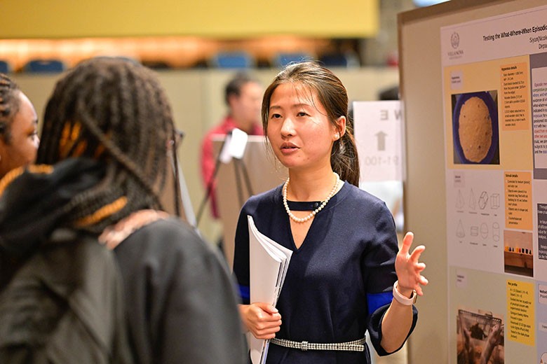 Woman speaking to student holding papers. 