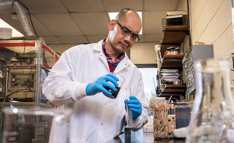 professor-pouring-liquid-tube Professor pouring liquid into tube