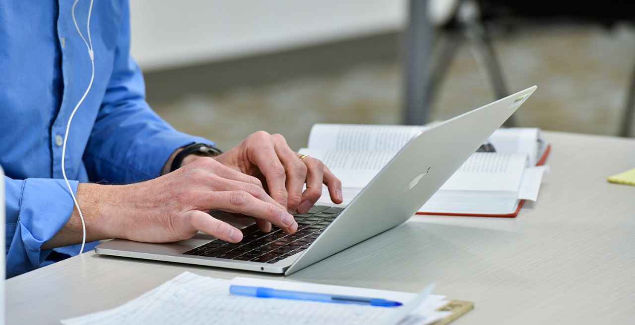 VIRS-research-management person typing on a laptop