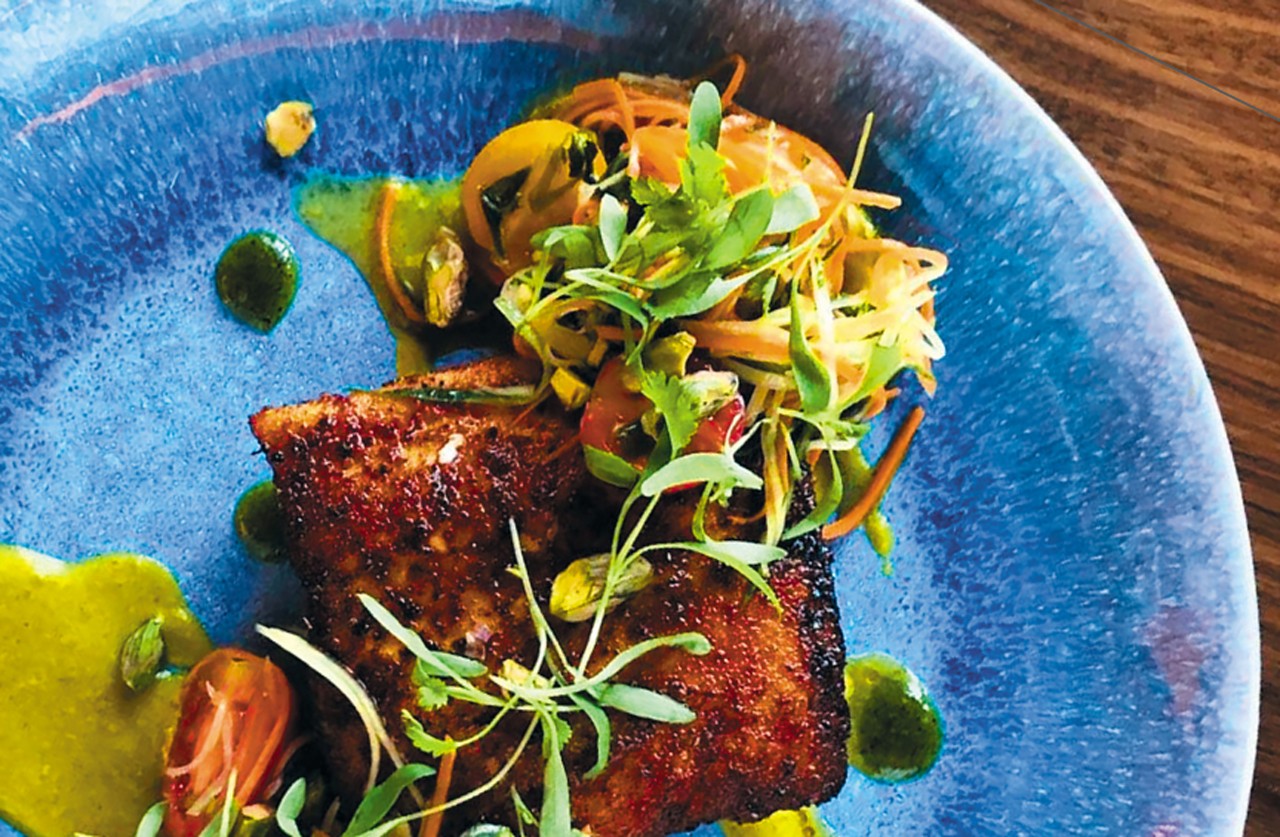 blackened Mahi Mahi with Papaya Salad, Jalapeño Emulsion and Coconut Curry on a blue plate