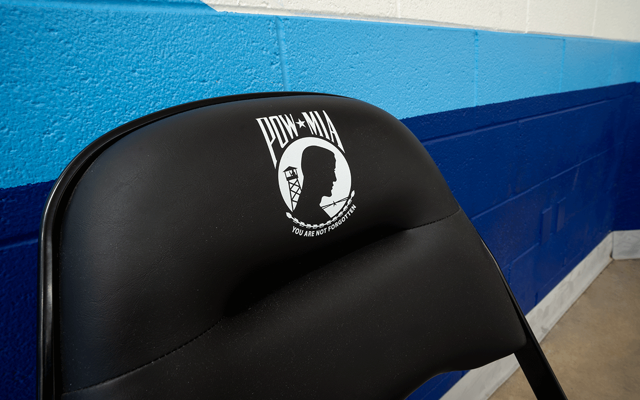 Black folding chair in Finneran Pavillion bears the "POW/MIA" emblem